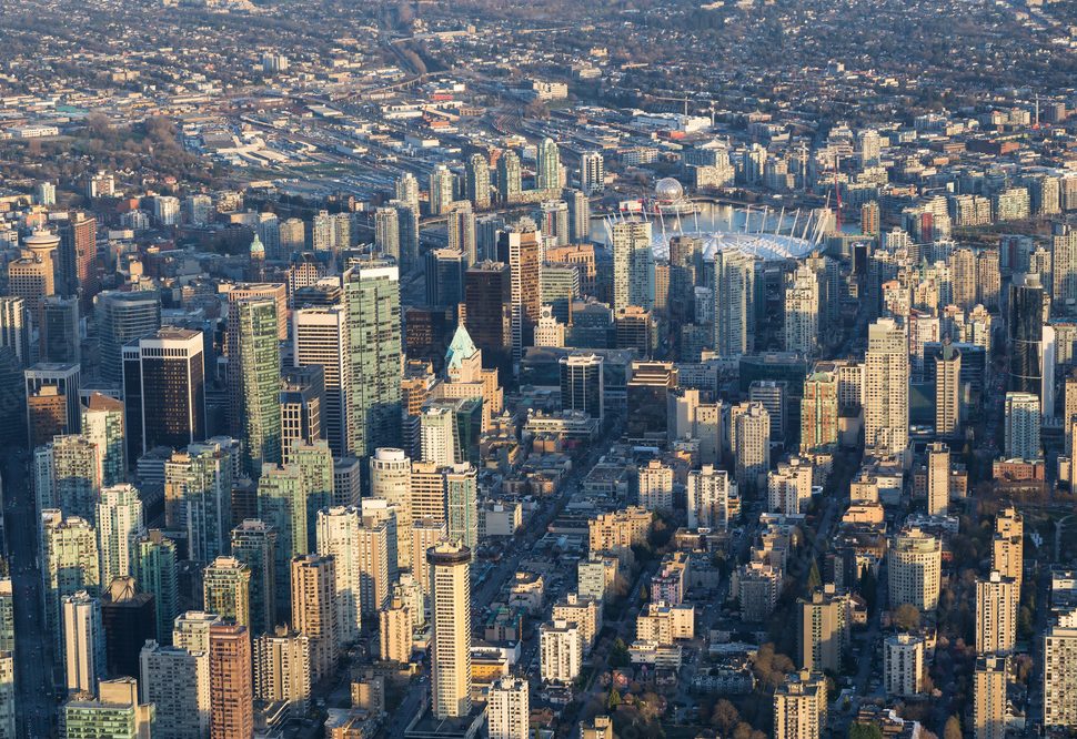 Aerial view of downtown Vancouver, showcasing skyscrapers and surrounding urban areas during the day.