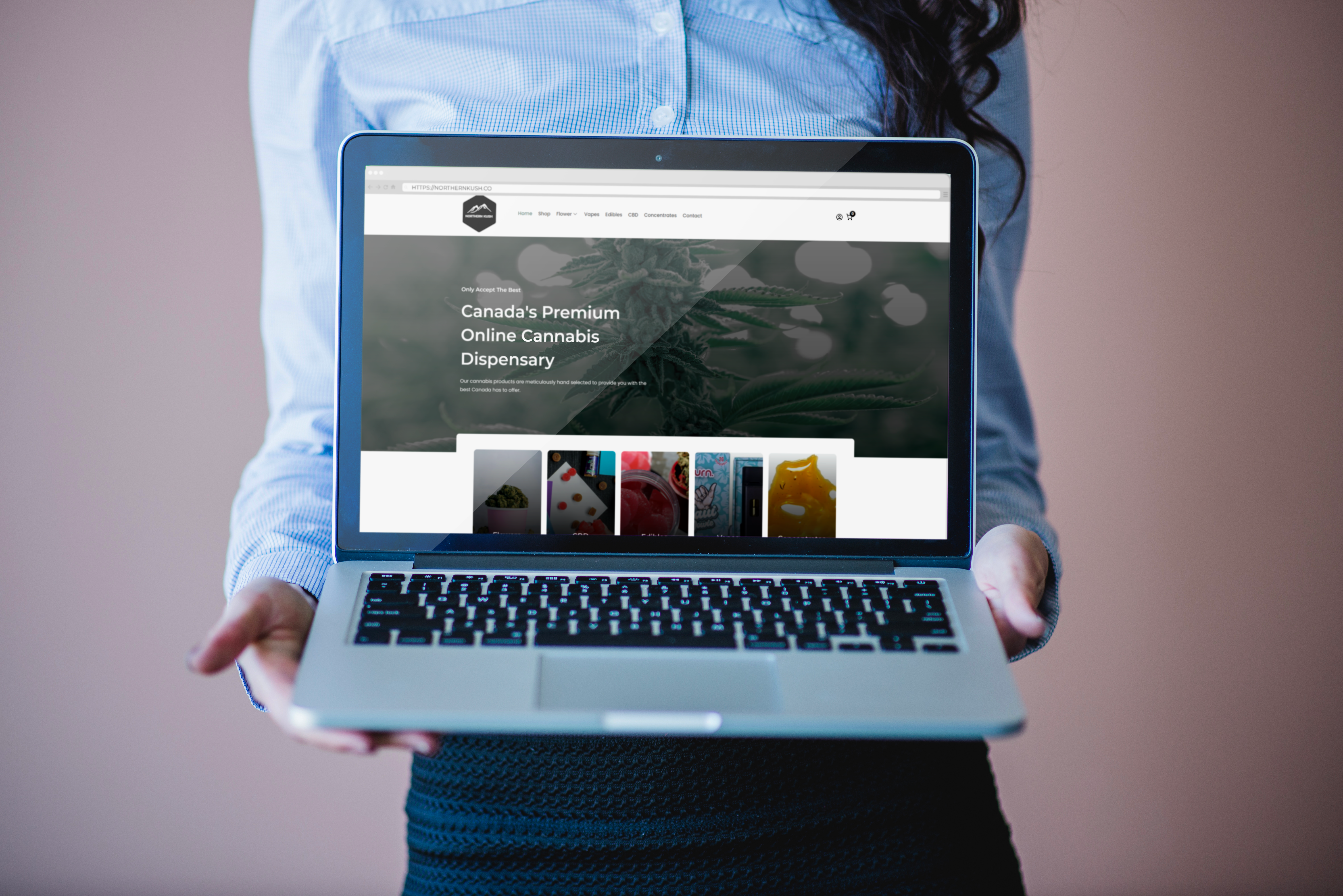 Person holding a laptop displaying the Northern Kush website, an online cannabis dispensary in British Columbia.